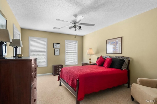 carpeted bedroom featuring a textured ceiling and ceiling fan