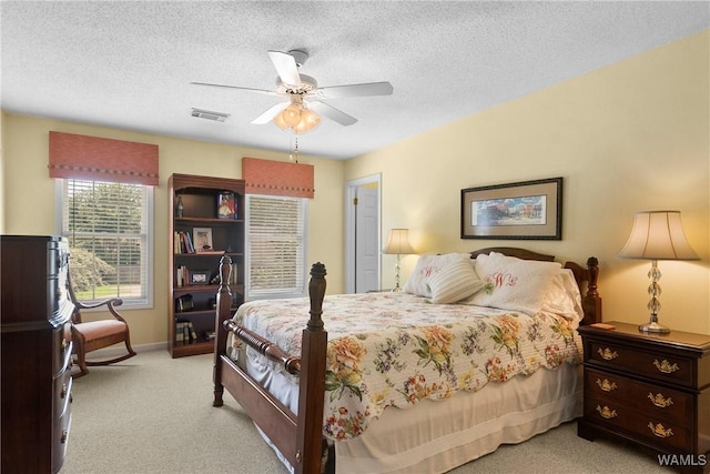 carpeted bedroom with a textured ceiling and ceiling fan