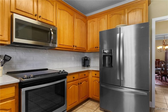 kitchen featuring light tile patterned floors, tasteful backsplash, a notable chandelier, and appliances with stainless steel finishes