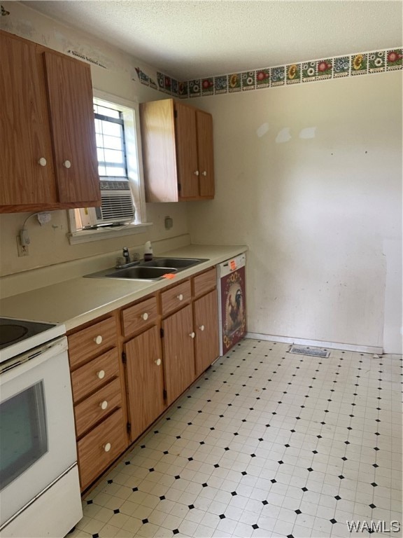 kitchen featuring white appliances, cooling unit, sink, a textured ceiling, and washer / dryer