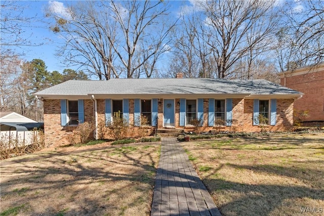 single story home featuring brick siding, a front lawn, and fence