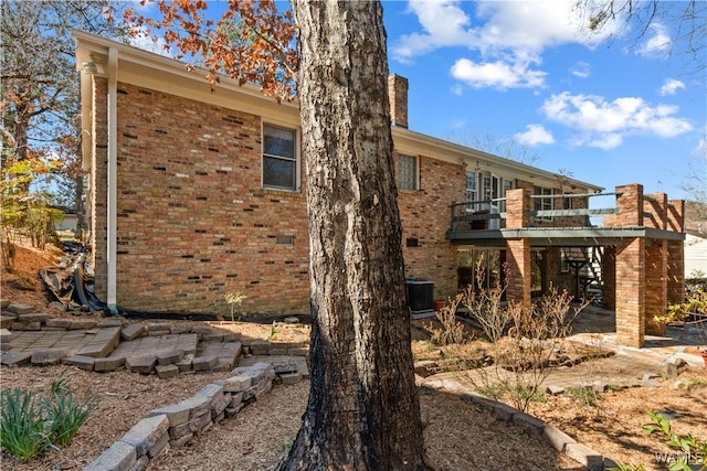 view of side of home with brick siding and a chimney