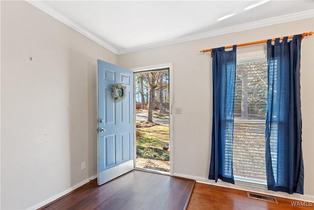 entrance foyer featuring ornamental molding, dark wood-style flooring, visible vents, and baseboards