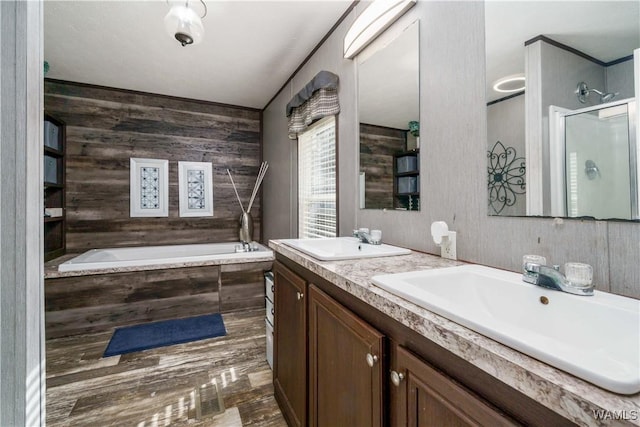 bathroom with independent shower and bath, vanity, and wood-type flooring