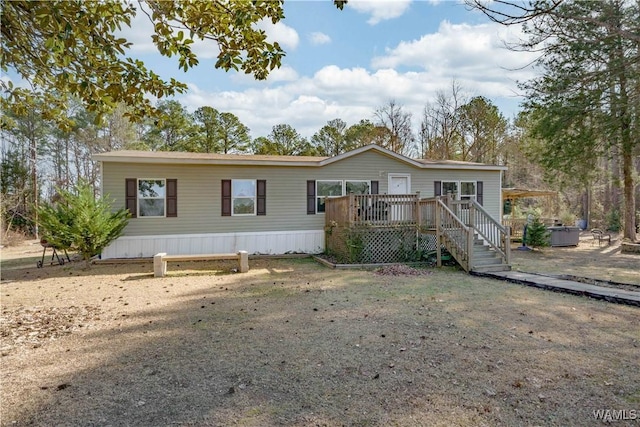 manufactured / mobile home with a hot tub and a deck