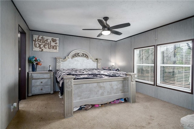 carpeted bedroom featuring crown molding and ceiling fan