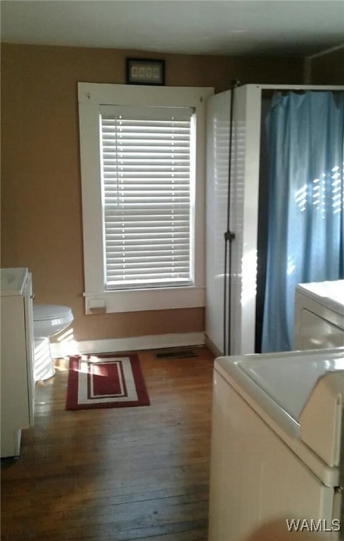 clothes washing area with hardwood / wood-style flooring