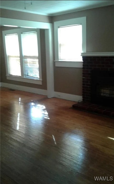 unfurnished living room featuring hardwood / wood-style floors, a healthy amount of sunlight, and a fireplace