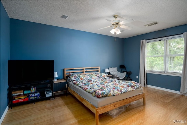 1400 Greymont Ln, Tuscaloosa, AL 35406 - bedroom with wood finished floors, a textured ceiling, baseboards, and ceiling fan