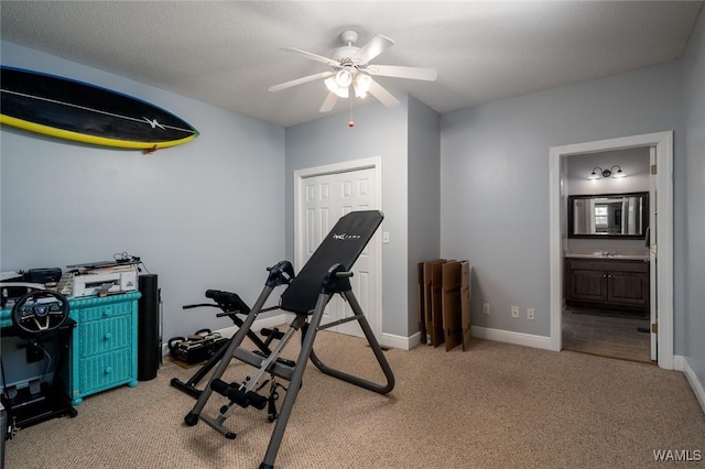 exercise area featuring light carpet, sink, and ceiling fan