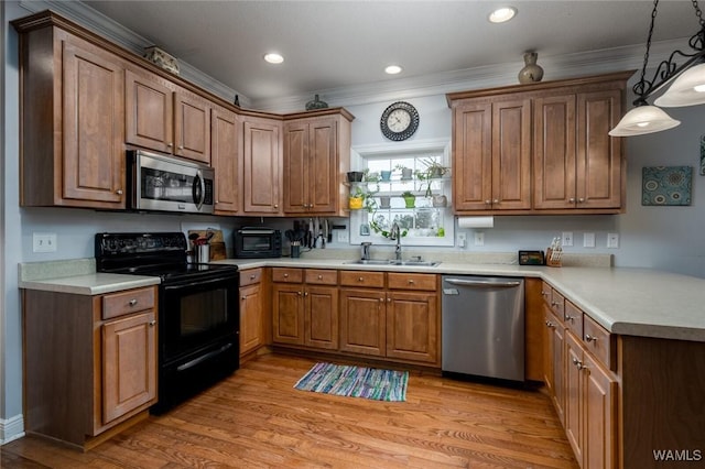 kitchen featuring sink, hanging light fixtures, stainless steel appliances, crown molding, and light hardwood / wood-style flooring