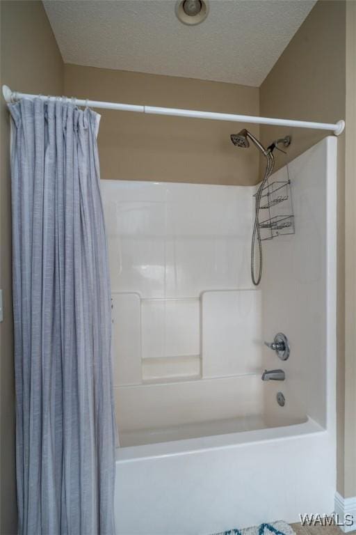 bathroom with a textured ceiling and shower / bath combo with shower curtain