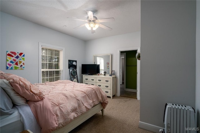 carpeted bedroom with radiator, a textured ceiling, and ceiling fan