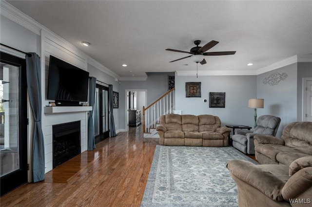 living room with hardwood / wood-style flooring, ornamental molding, and ceiling fan