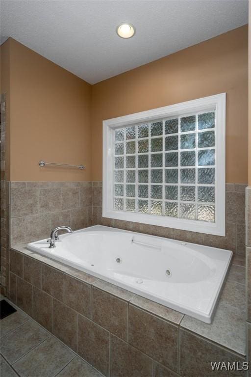 bathroom with a wealth of natural light, tiled bath, and tile patterned floors