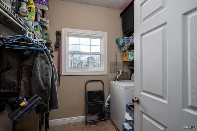 laundry area featuring washer / clothes dryer, a textured ceiling, and light tile patterned floors