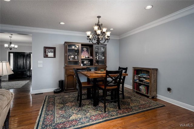 dining area with an inviting chandelier, crown molding, dark hardwood / wood-style floors, and a textured ceiling