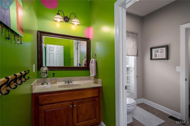 bathroom featuring vanity, toilet, and tile patterned flooring