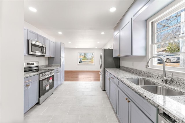 kitchen with stainless steel appliances, recessed lighting, gray cabinets, and a sink