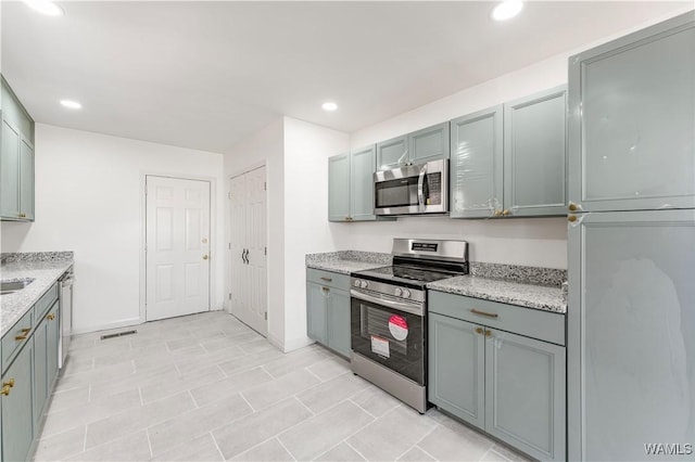 kitchen featuring recessed lighting, stainless steel appliances, visible vents, baseboards, and light stone countertops