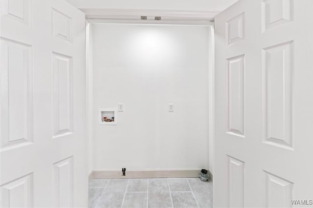 clothes washing area featuring light tile patterned floors, laundry area, washer hookup, and baseboards