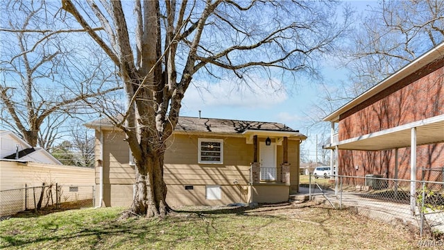 back of house featuring crawl space, central AC, fence, and a lawn