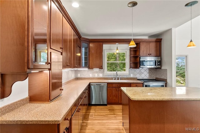 6803 Emerald Ln, Tuscaloosa, AL 35406 - kitchen with stainless steel appliances, a sink, light wood-style flooring, glass insert cabinets, and brown cabinetry