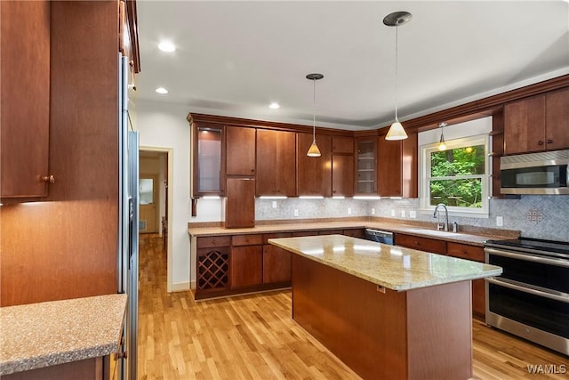 6803 Emerald Ln, Tuscaloosa, AL 35406 - kitchen with stainless steel appliances, light wood-style flooring, backsplash, a sink, and glass insert cabinets