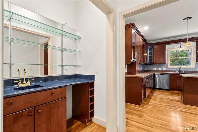 6803 Emerald Ln, Tuscaloosa, AL 35406 - indoor wet bar with stainless steel dishwasher, light wood-style floors, backsplash, decorative light fixtures, and baseboards