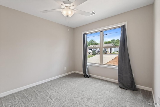 carpeted spare room featuring ceiling fan