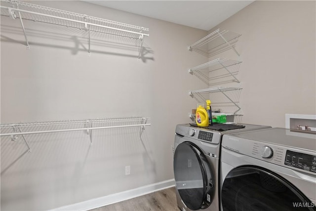 laundry area with hardwood / wood-style flooring and independent washer and dryer