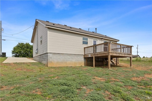 back of property with a lawn and a wooden deck