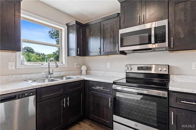 kitchen featuring dark wood-type flooring, sink, dark brown cabinetry, and appliances with stainless steel finishes