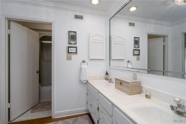 bathroom with a sink, visible vents, and crown molding