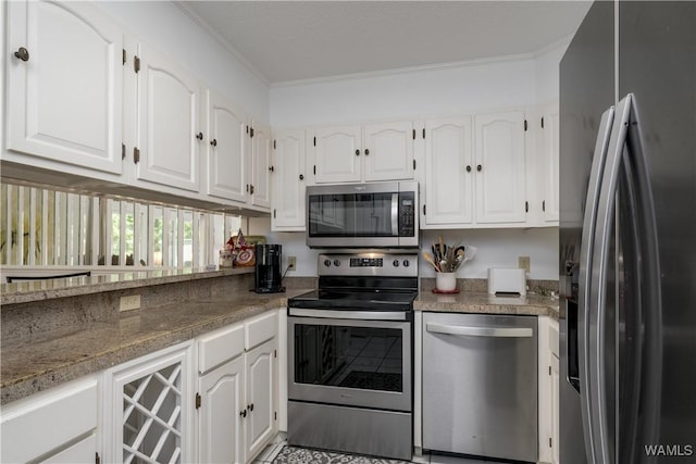 kitchen featuring stainless steel appliances, white cabinetry, and crown molding