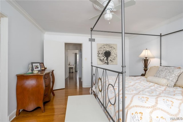 bedroom featuring visible vents, crown molding, and wood finished floors