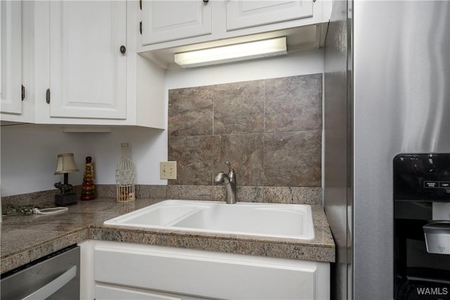 kitchen featuring tile countertops, a sink, white cabinets, and stainless steel dishwasher