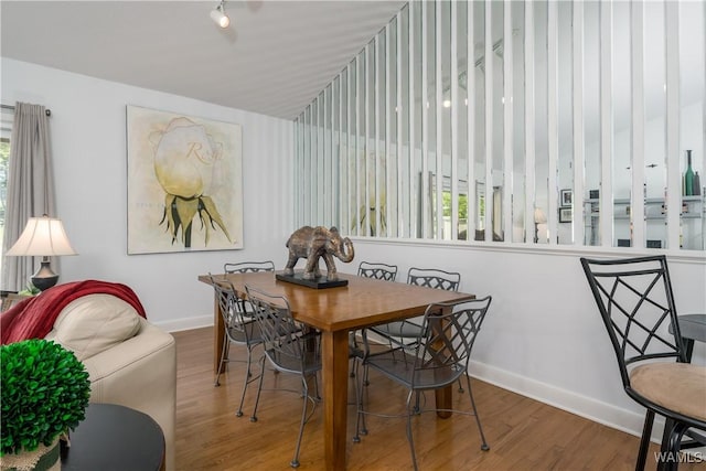 dining room featuring a wealth of natural light, baseboards, and wood finished floors