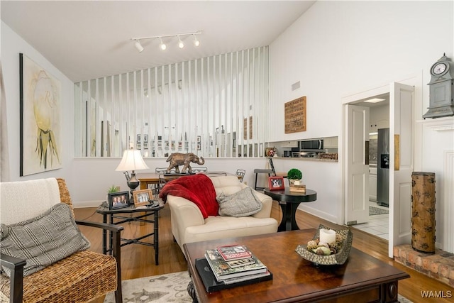 living area featuring visible vents, baseboards, and wood finished floors