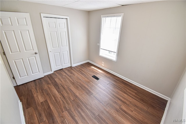 unfurnished bedroom with dark hardwood / wood-style floors and a closet