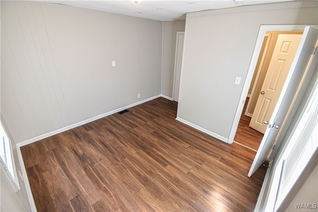 spare room with dark wood-type flooring