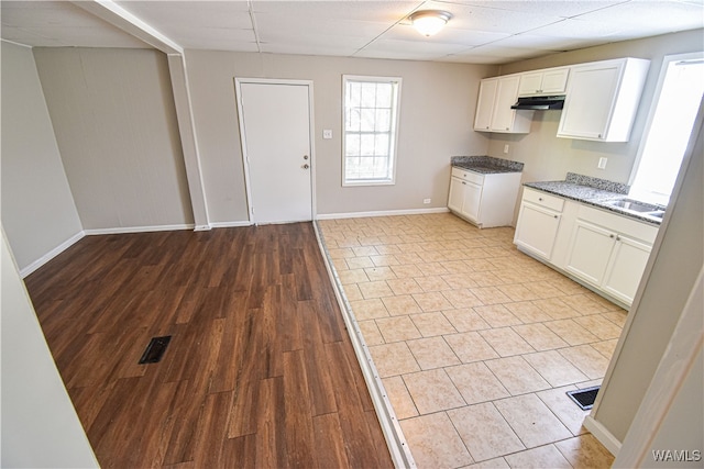 kitchen with white cabinetry, sink, and light hardwood / wood-style floors