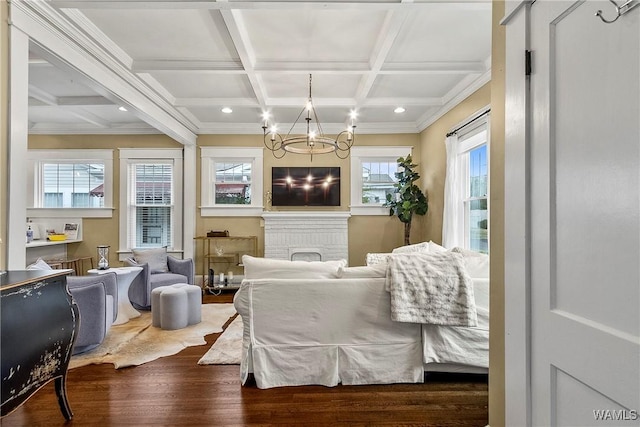 sitting room with coffered ceiling, wood finished floors, beam ceiling, a fireplace, and a notable chandelier