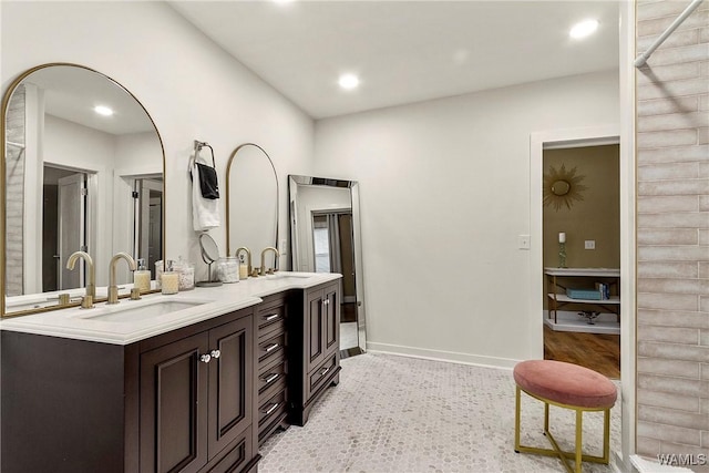 bathroom with double vanity, recessed lighting, a sink, and baseboards