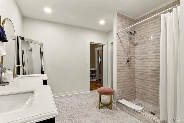 full bath featuring recessed lighting, tiled shower, vanity, and baseboards