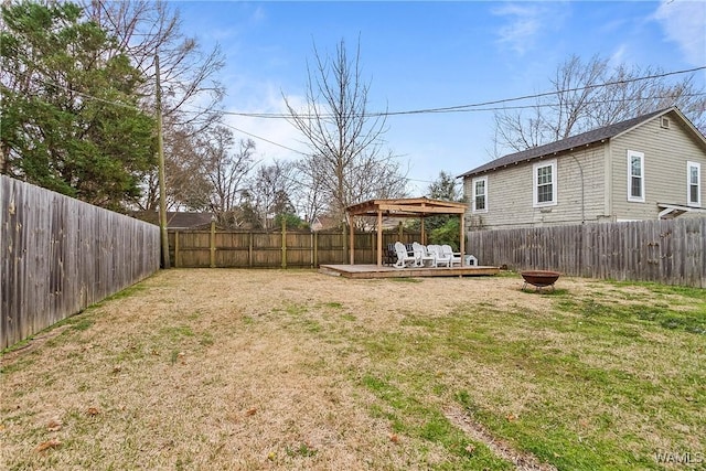 view of yard featuring a fire pit, a gazebo, a fenced backyard, and a wooden deck