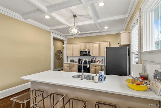 kitchen featuring coffered ceiling, appliances with stainless steel finishes, a breakfast bar, a peninsula, and backsplash