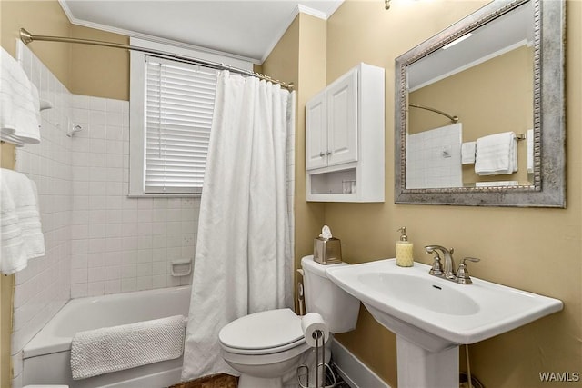 bathroom with ornamental molding, shower / bath combination with curtain, a sink, and toilet