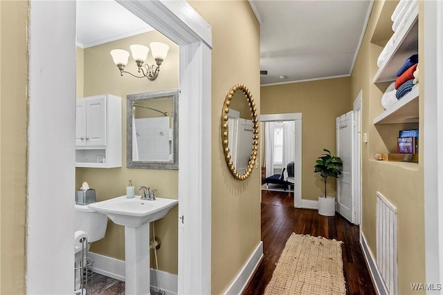 full bathroom featuring crown molding, visible vents, a sink, wood finished floors, and baseboards