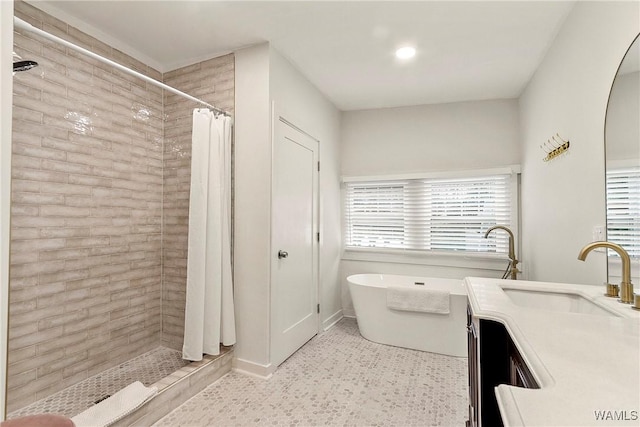 full bath with tiled shower, a freestanding tub, and vanity